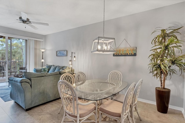 tiled dining space with ceiling fan with notable chandelier