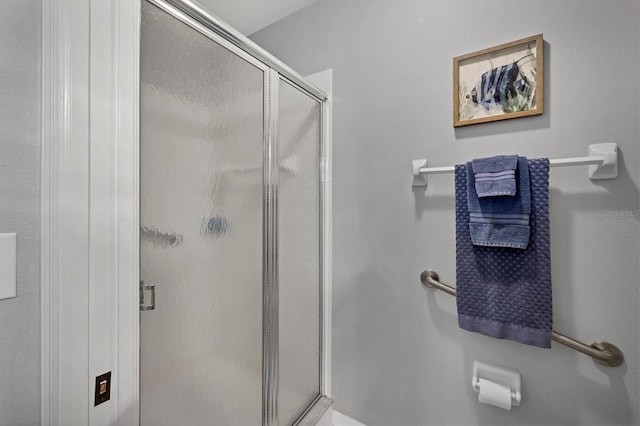 bathroom featuring a shower with door