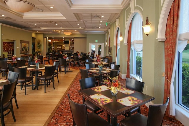 dining area featuring coffered ceiling, ornamental molding, beam ceiling, and light hardwood / wood-style floors