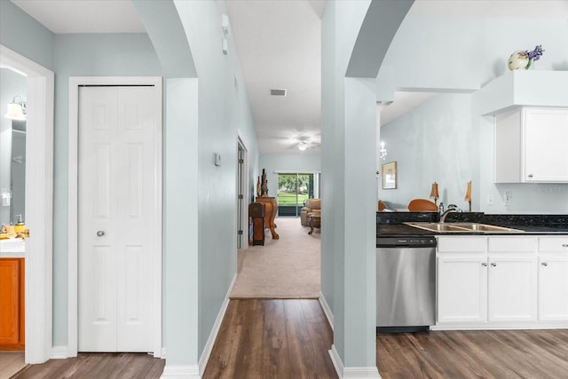 kitchen with stainless steel dishwasher, sink, white cabinets, and dark hardwood / wood-style floors