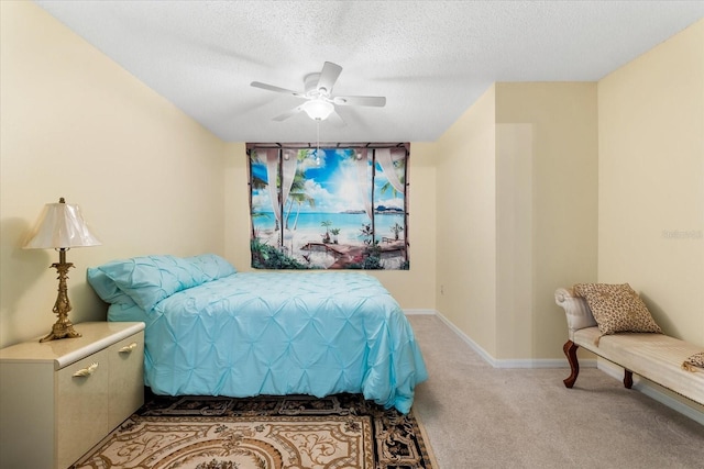 carpeted bedroom featuring a textured ceiling and ceiling fan