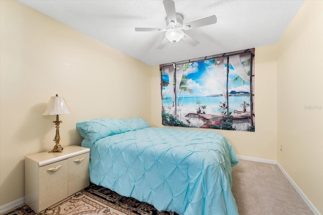 carpeted bedroom featuring a textured ceiling and ceiling fan