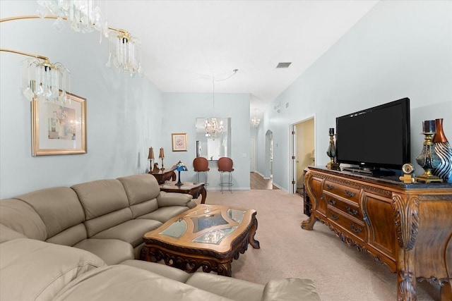 living room featuring carpet flooring, vaulted ceiling, and a chandelier