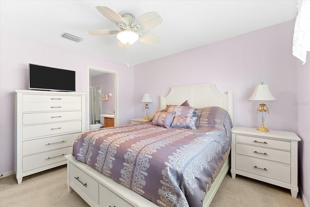 bedroom featuring ensuite bath, light colored carpet, and ceiling fan