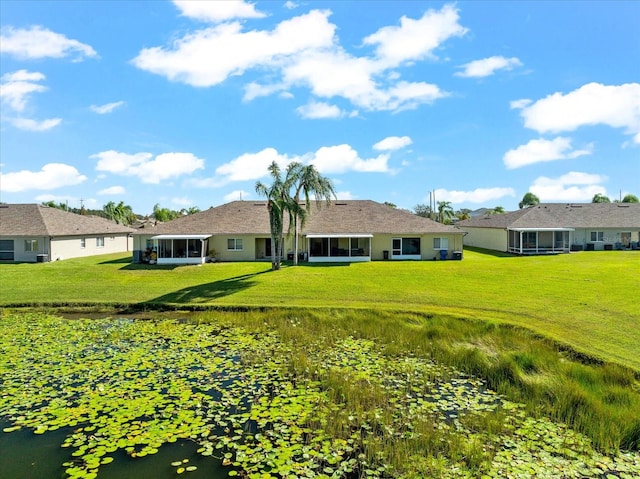 rear view of property with a sunroom and a lawn