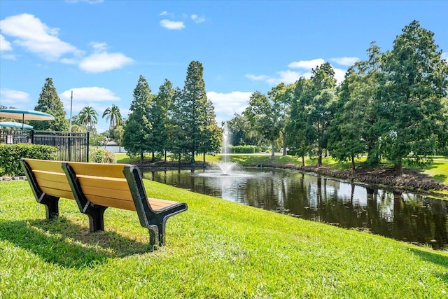 view of community with a water view and a lawn