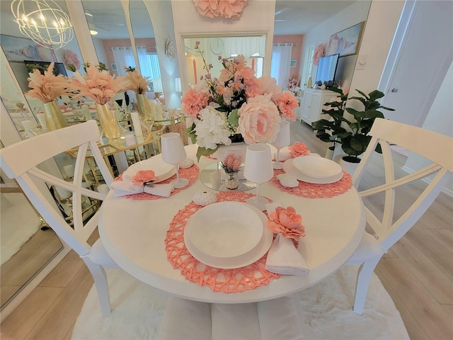 dining room with an inviting chandelier, light hardwood / wood-style floors, and a healthy amount of sunlight