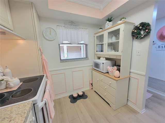 kitchen featuring light hardwood / wood-style floors, white appliances, and ornamental molding