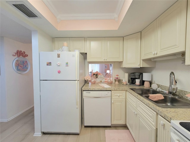 kitchen with a raised ceiling, white appliances, and ornamental molding