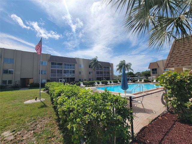 view of swimming pool featuring a yard