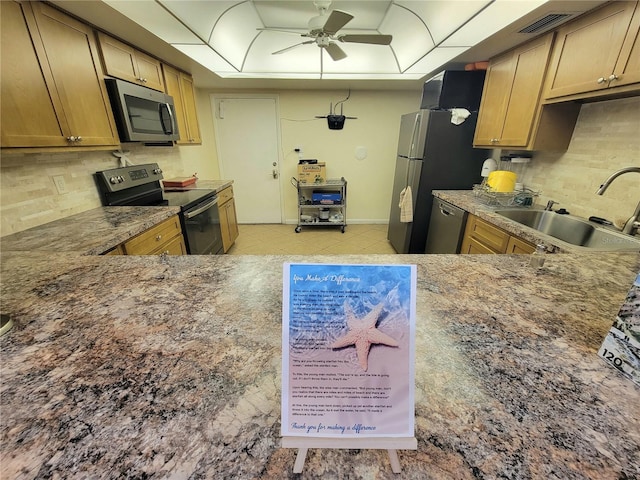 kitchen with ceiling fan, sink, tasteful backsplash, stone counters, and stainless steel appliances