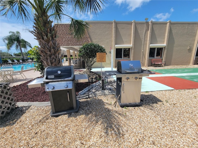 exterior space with a fenced in pool and a grill