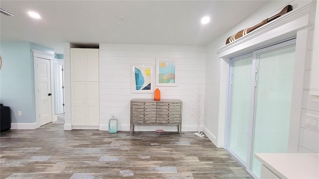 mudroom with wood walls and light hardwood / wood-style floors