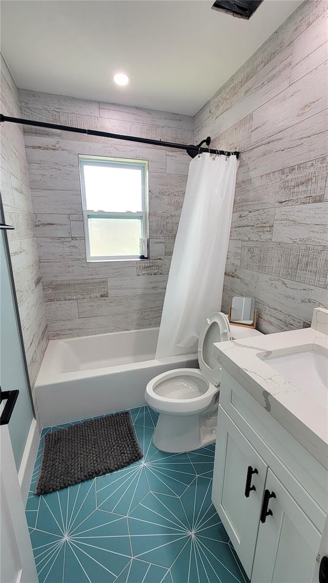 full bathroom with tile walls, vanity, shower / bath combination with curtain, tile patterned flooring, and toilet