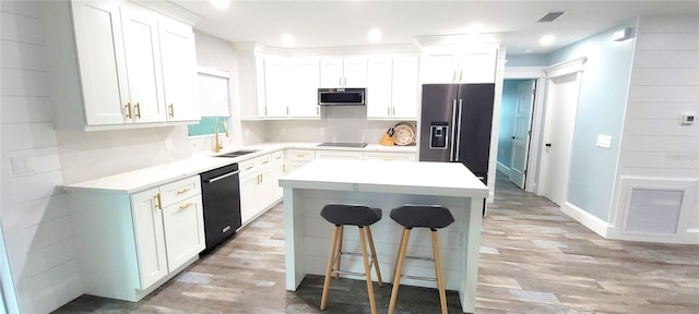 kitchen featuring appliances with stainless steel finishes, a center island, white cabinetry, and sink