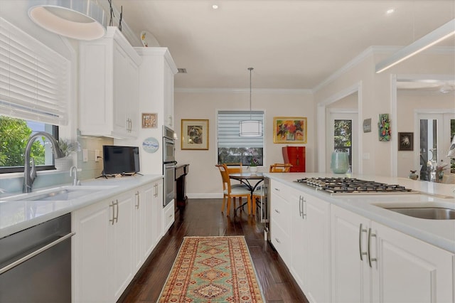 kitchen with dark hardwood / wood-style flooring, appliances with stainless steel finishes, white cabinetry, pendant lighting, and sink