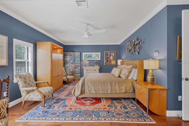 bedroom featuring crown molding, hardwood / wood-style flooring, and ceiling fan