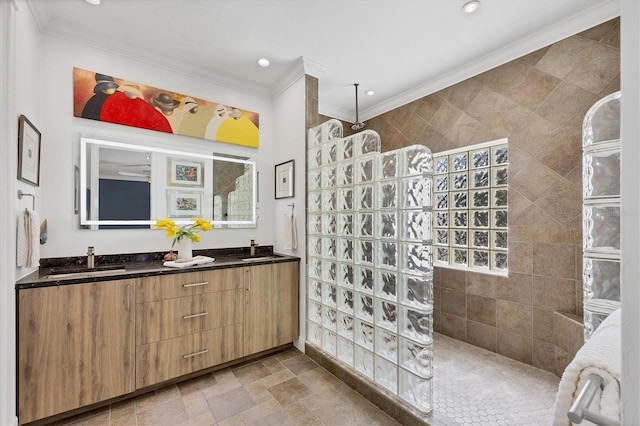 bathroom featuring vanity, crown molding, a shower, and tile walls