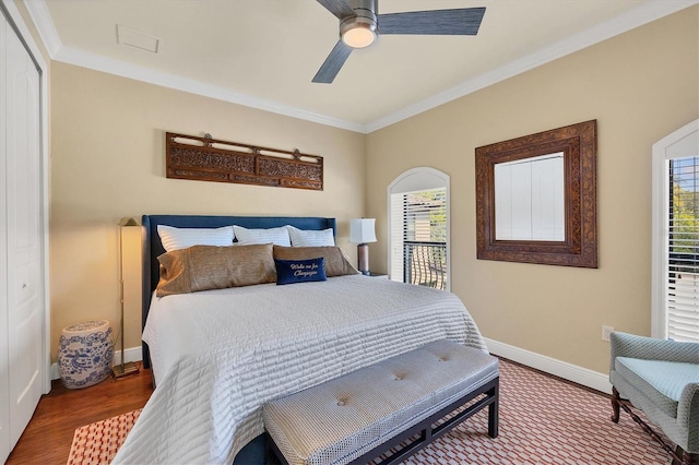 bedroom featuring a closet, hardwood / wood-style floors, crown molding, and ceiling fan