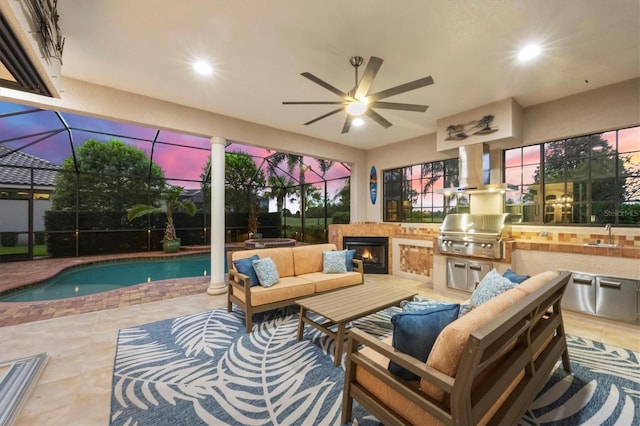 patio terrace at dusk with a grill, an outdoor living space, area for grilling, glass enclosure, and ceiling fan