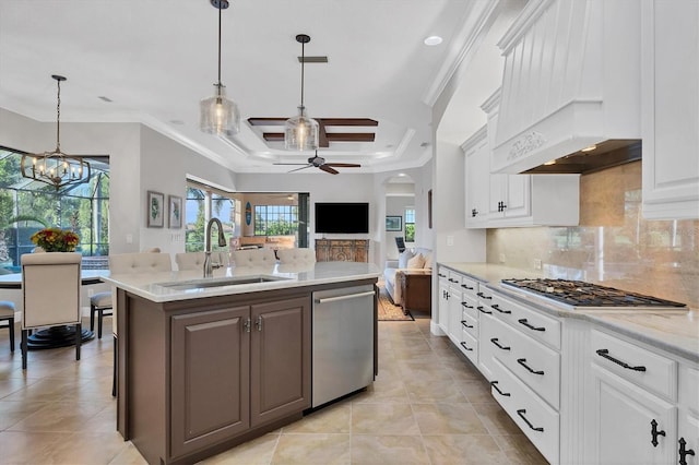 kitchen featuring custom range hood, white cabinets, pendant lighting, stainless steel appliances, and sink