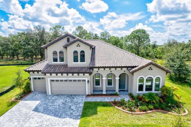 14607 Swiss Bridge Dr, Lithia, FL 33547 - mediterranean / spanish-style house featuring a porch, a front lawn, a garage, decorative driveway, and stucco siding