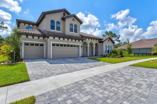 14607 Swiss Bridge Dr, Lithia, FL 33547 - mediterranean / spanish-style home featuring a front lawn, decorative driveway, stucco siding, and fence