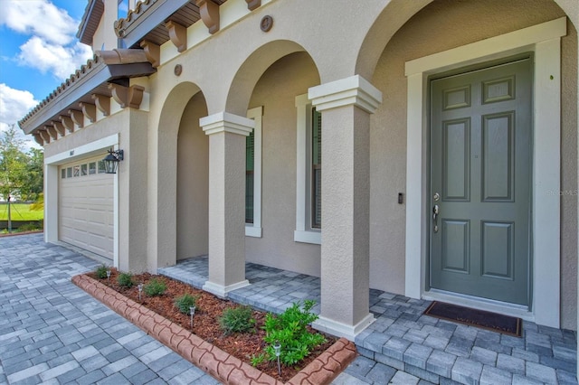 14607 Swiss Bridge Dr, Lithia, FL 33547 - property entrance with a garage, stucco siding, and decorative driveway