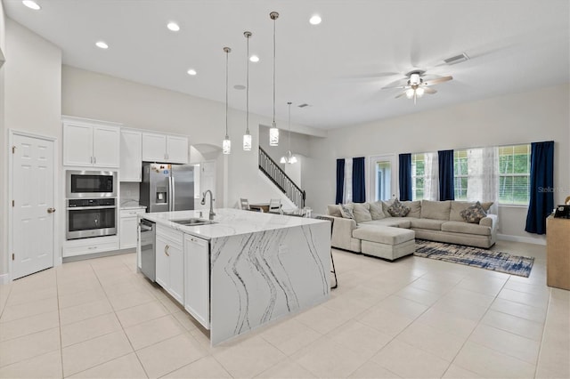 14607 Swiss Bridge Dr, Lithia, FL 33547 - kitchen with a sink, light tile patterned floors, ceiling fan, white cabinets, and appliances with stainless steel finishes