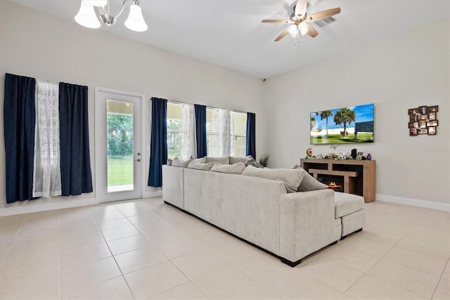 tiled living room featuring ceiling fan with notable chandelier