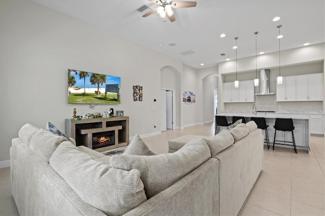 14607 Swiss Bridge Dr, Lithia, FL 33547 - living room with ceiling fan, visible vents, arched walkways, a glass covered fireplace, and recessed lighting
