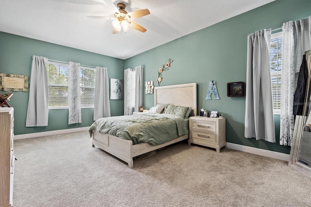 carpeted bedroom featuring ceiling fan and multiple windows