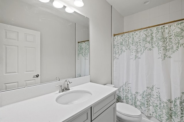 full bathroom with vanity, shower / tub combo, and toilet