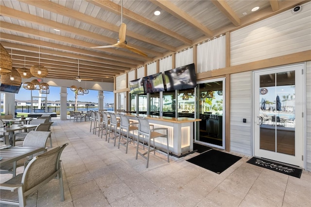 interior space featuring ceiling fan and a bar