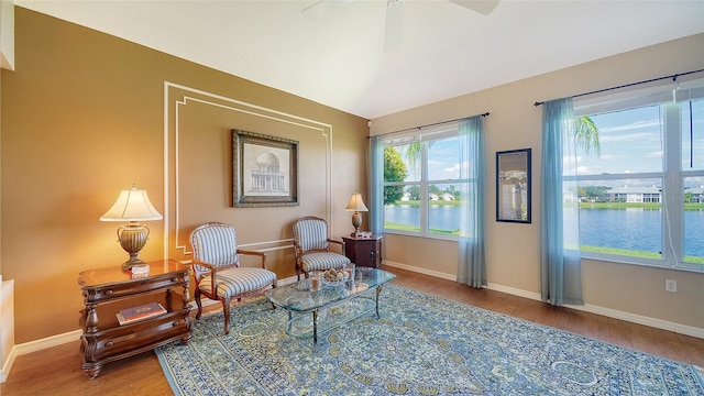 sitting room with a water view and wood-type flooring