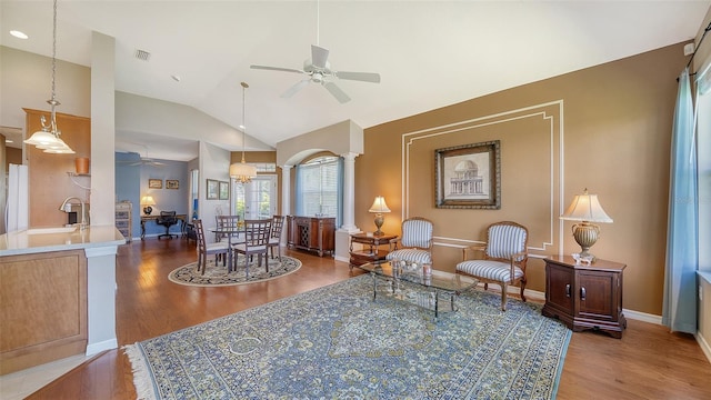 living room featuring ornate columns, ceiling fan, hardwood / wood-style floors, and lofted ceiling