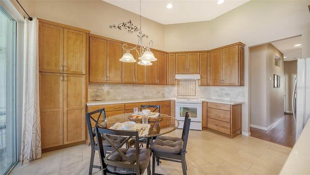 kitchen with tasteful backsplash, white range with electric cooktop, a chandelier, and decorative light fixtures