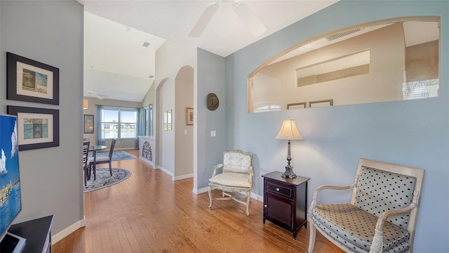 sitting room featuring ceiling fan, vaulted ceiling, and light wood-type flooring