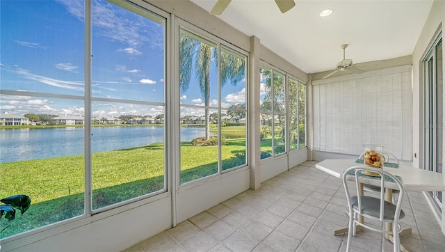 unfurnished sunroom with a water view, a wealth of natural light, and ceiling fan