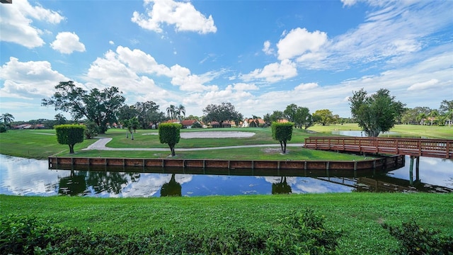 view of home's community with a lawn and a water view