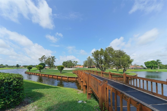 view of dock featuring a lawn and a water view