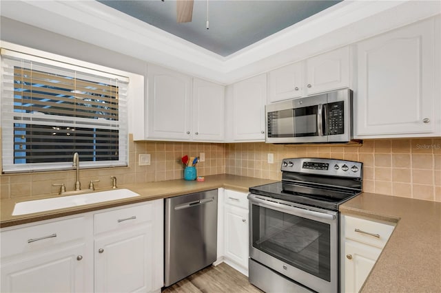 kitchen with sink, white cabinets, and appliances with stainless steel finishes