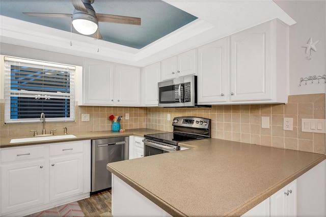 kitchen with decorative backsplash, sink, white cabinets, and appliances with stainless steel finishes