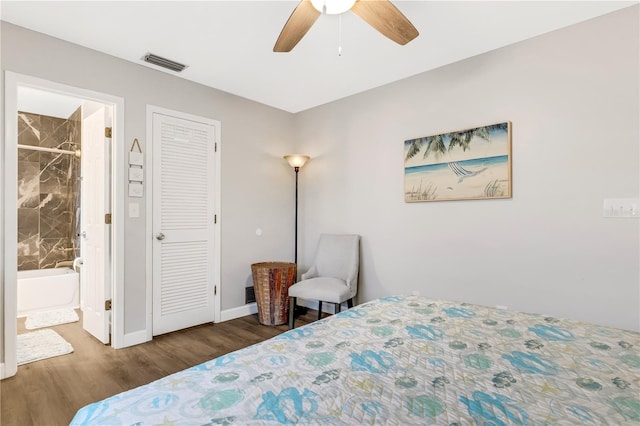 bedroom featuring ceiling fan, dark hardwood / wood-style floors, and connected bathroom