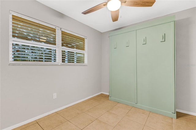 unfurnished bedroom with ceiling fan, a closet, and light tile patterned flooring