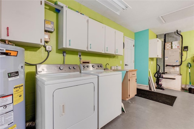 laundry area featuring washing machine and clothes dryer, electric water heater, and cabinets