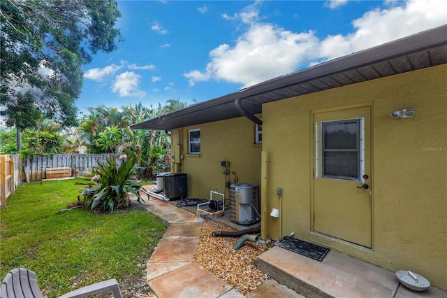 property entrance featuring a yard and central AC unit