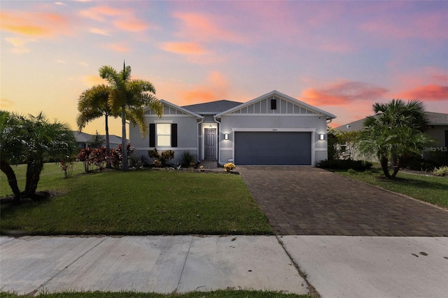 ranch-style house with a garage and a yard