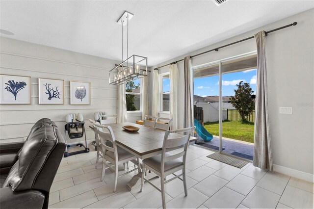 tiled dining space featuring a notable chandelier