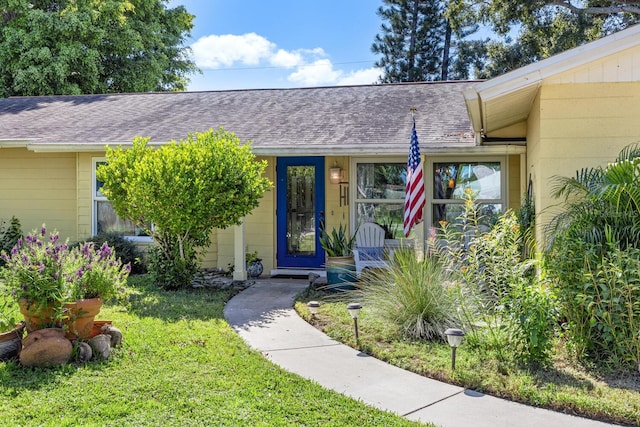 view of exterior entry with a lawn